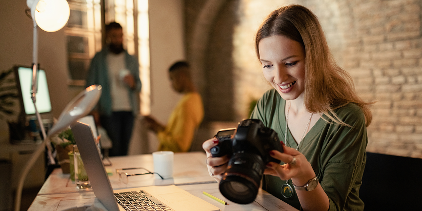 Junge Fotografin prüft ihre Aufnahmen an der Kamera in einem modernen Studio